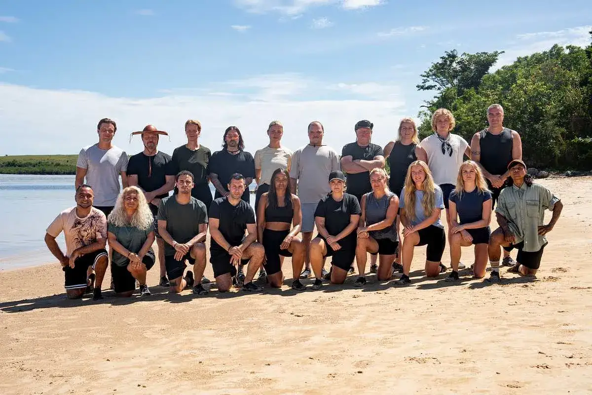En grupp robinson deltagare poserar p&aring; en sandstrand.