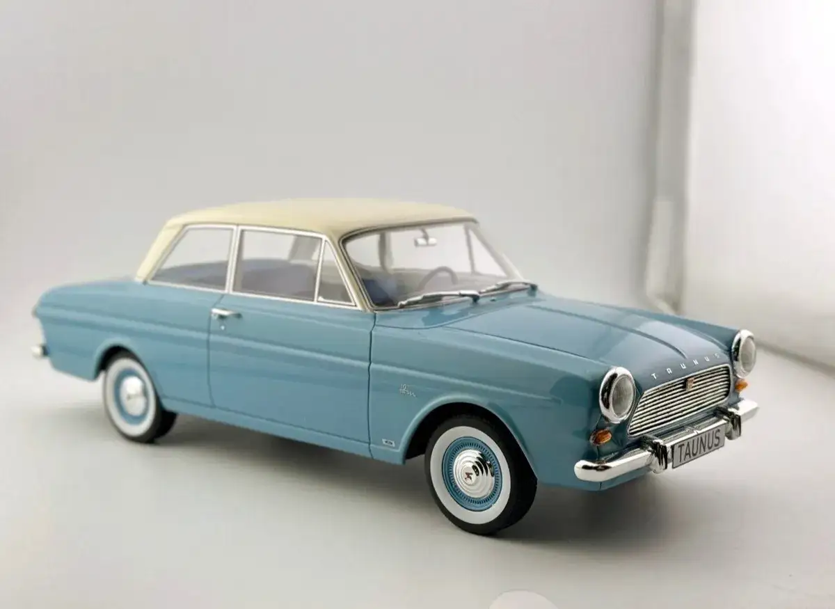 En bl&aring; Ford Taunus 12M med beige tak, en klassisk bilmodell.