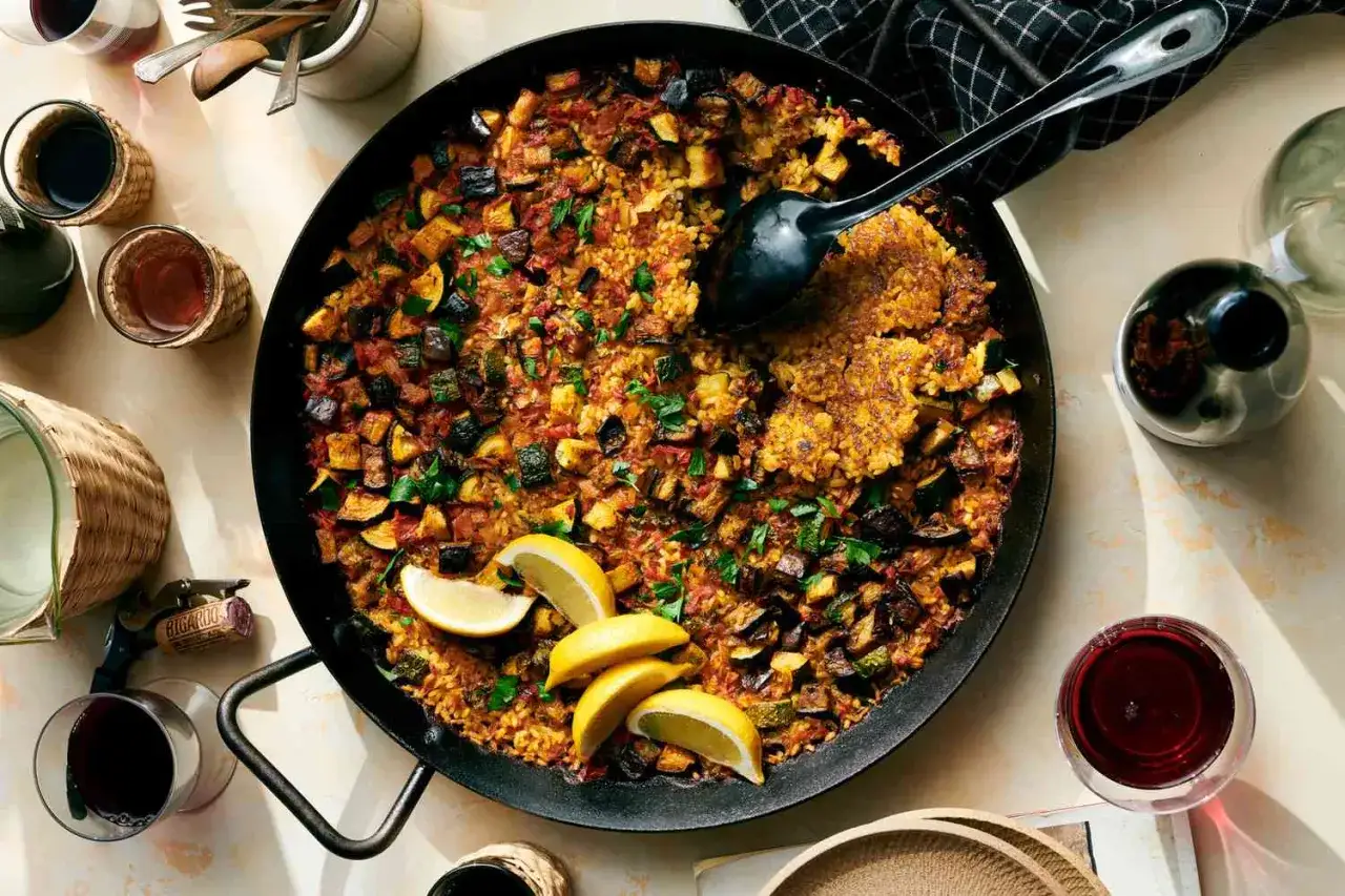 En stor paella med grönsaker, citronklyftor och persilja. En härlig rätt bland många goda risrecept.