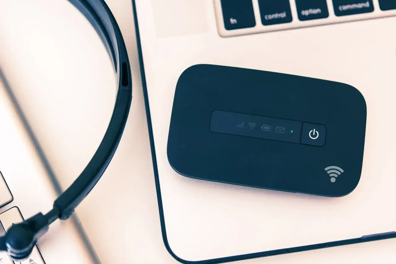 Przenośny router Wi-Fi, słuchawki i klawiatura laptopa. Twój mobilny hot spot do pracy i rozrywki.