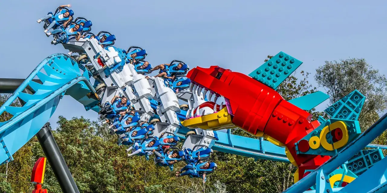 Dzieci i dorośli szaleją na kolejce górskiej w kształcie smoka z klocków Lego Land.
