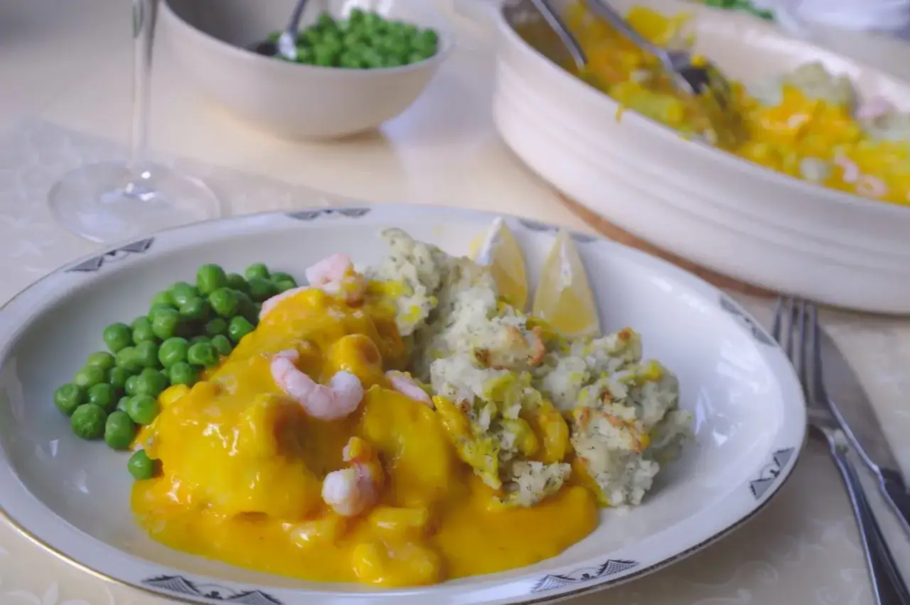 Lyxig torskrygg i ugn med krämig sås, räkor, ärtor och potatis. Ett perfekt recept för en festlig middag.