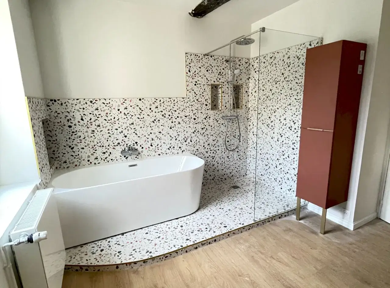 &Eacute;l&eacute;gante salle de bain 10m2 avec baignoire &icirc;lot, douche &agrave; l'italienne et meuble haut en terracotta.