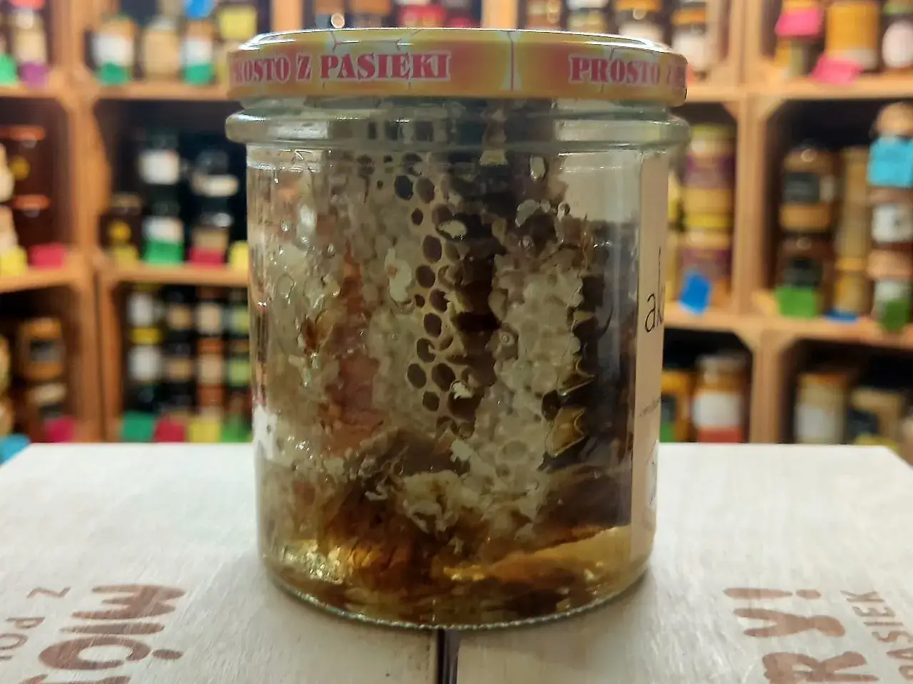 Słoik z plastrem miodu, dowód na to, czy miód jest zdrowy. Naturalny produkt z pasieki, pełen słodyczy i dobroci.
