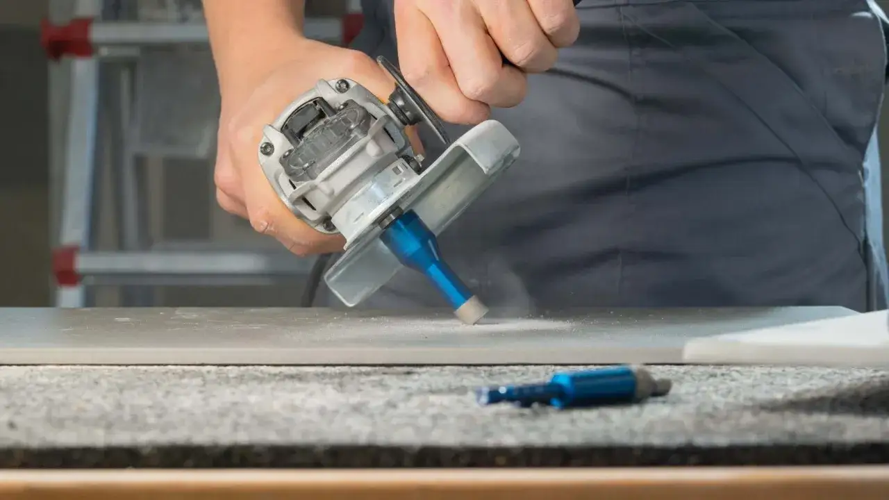 Pr&auml;zises Bohren von Fliesen mit einem Winkelschleifer und Diamantbohrer. Staub wirbelt auf, w&auml;hrend die Arbeit voranschreitet.