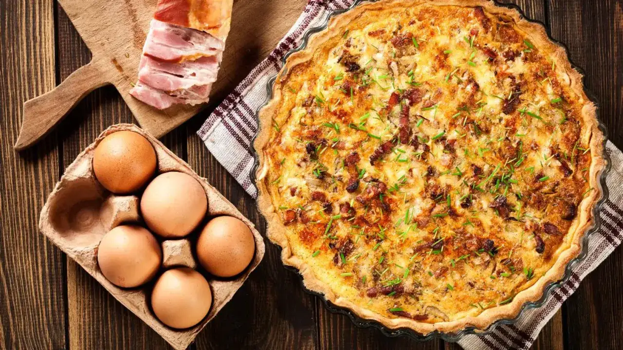 Quiche Lorraine prête à être dégustée. Les ingrédients : lardons, œufs, et la tarte dorée. Idéal pour connaître le quiche lorraine temps de cuisson et température.