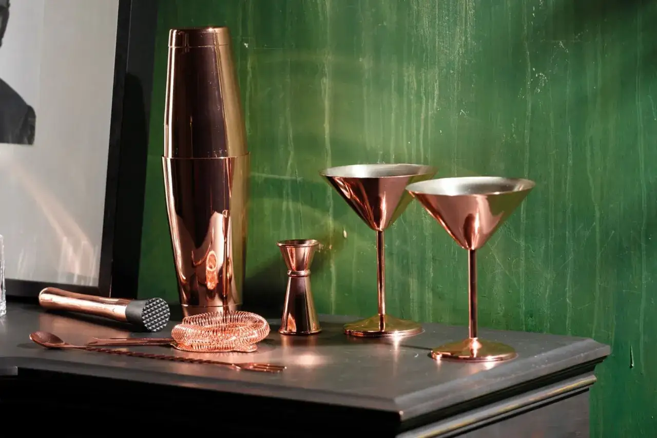 Set di attrezzi per cocktail in rame: shaker, bicchieri, jigger, strainer, muddler e cucchiaio. Perfetto per una lista di drink alcolici.