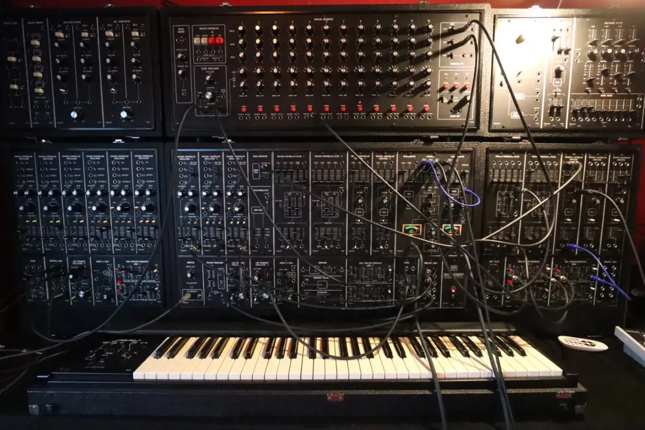 Ein komplexes Synthesizer-Setup mit vielen Reglern und Kabeln, bereit, epische Synth-Musik zu erzeugen.