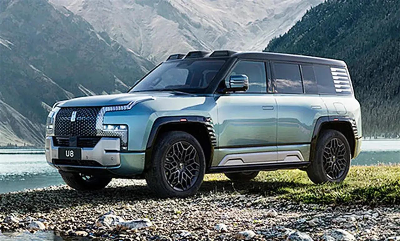 Der Yang Wang U8, ein robustes SUV, steht am Ufer eines Sees vor einer Bergkulisse.