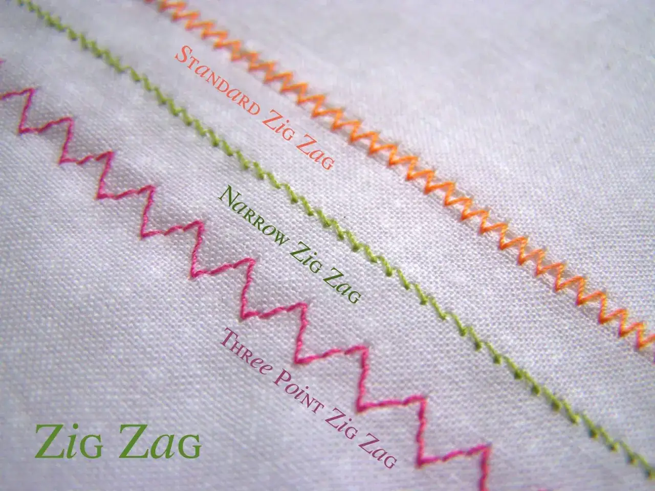 Three types of zig zag stitch shown on white fabric: standard orange, narrow green, and three-point pink.