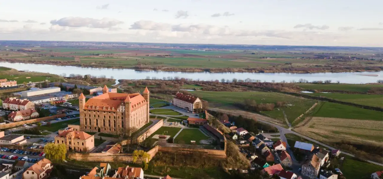 Zamek w Gniewie, majestatyczna twierdza nad Wisłą, kryje wiele ciekawostek. Widok z lotu ptaka ukazuje jego potęgę i malownicze położenie.
