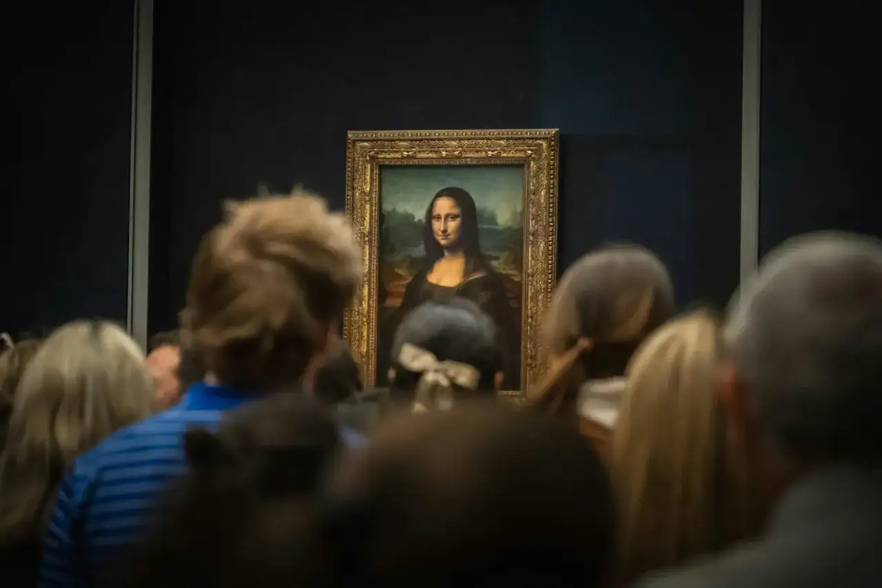 Tłum ludzi ogląda obraz Mona Lisa. Po tym, jak Mona Lisa została skradziona, wróciła na swoje miejsce.