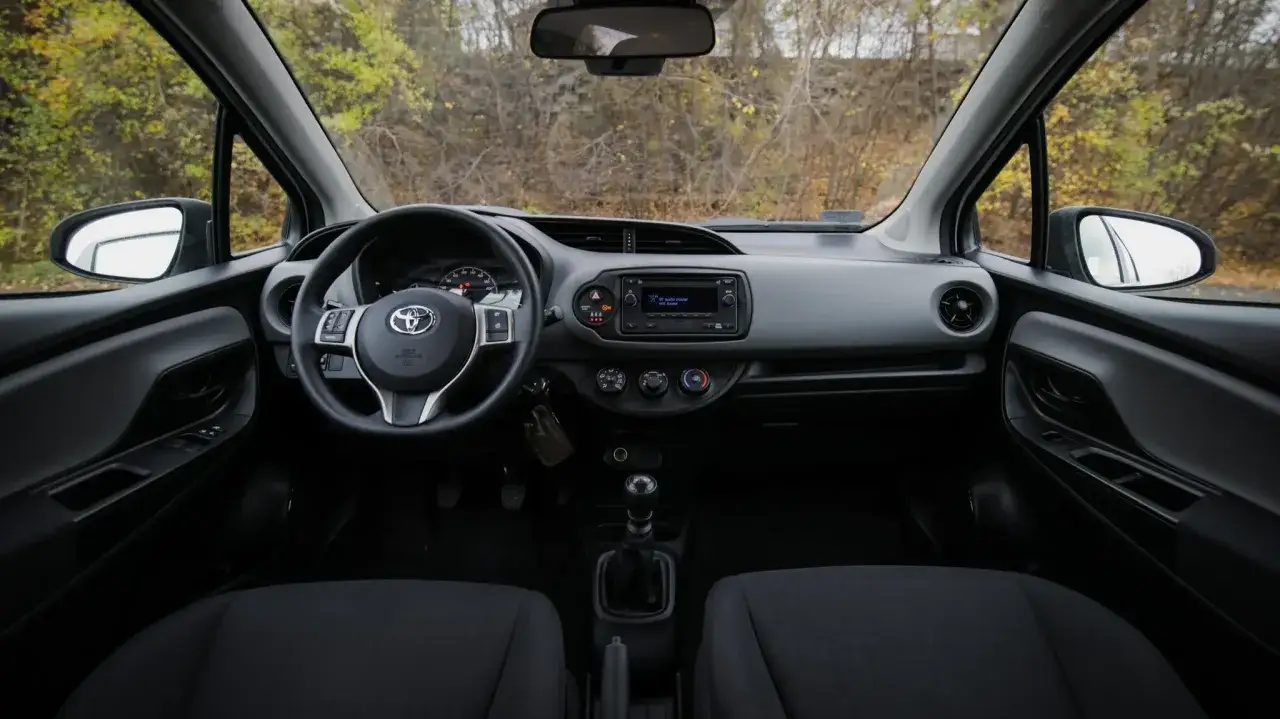 Wnętrze Toyoty Yaris 2017: kierownica, deska rozdzielcza z radiem i nawiewami, fotele.