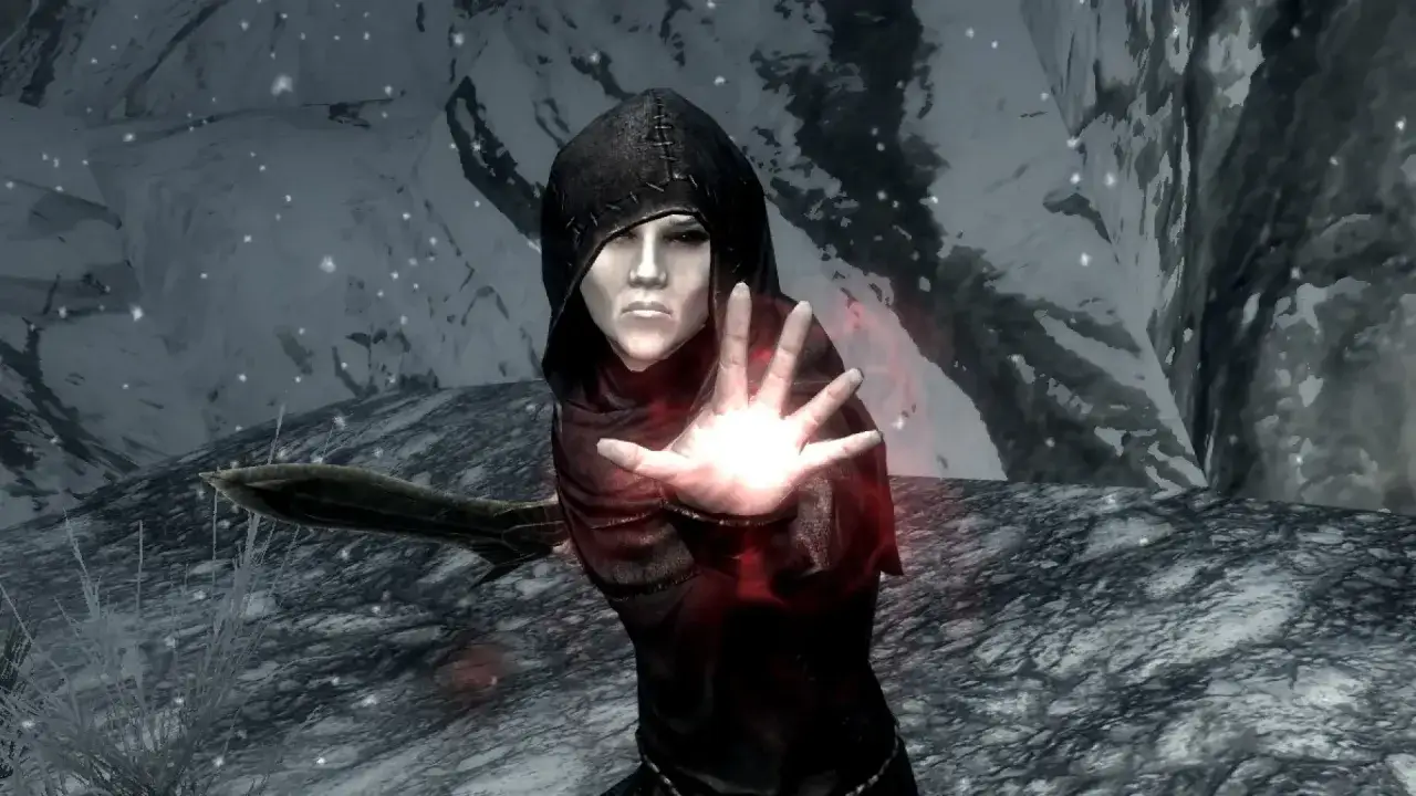 Una figura encapuchada en Skyrim, con la mano extendida y emitiendo luz roja, busca curar el vampirismo.