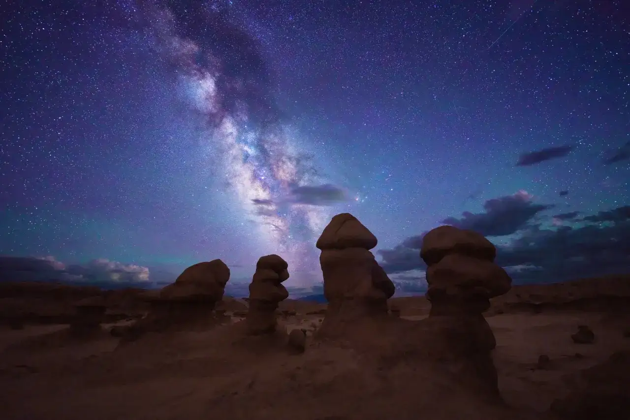 Nocne niebo nad formacjami skalnymi w Goblin Valley, Utah. Droga Mleczna rozciąga się nad dziwnymi kształtami, jakby z innego świata. Zdjęcie wykonane aparatem a7r5.