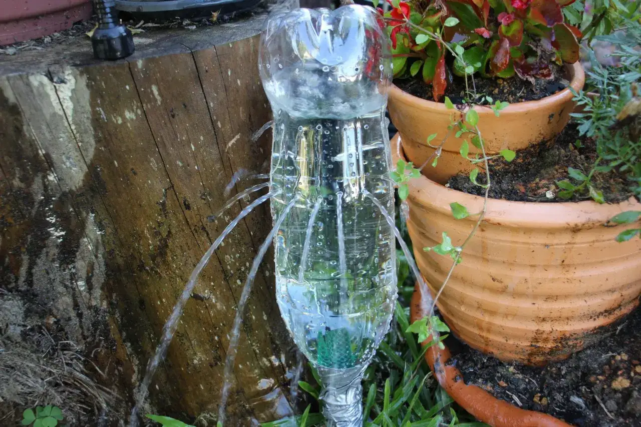 Ingegnosa irrigazione a goccia fai da te con bottiglia, che rilascia acqua lentamente alle piante in vaso.