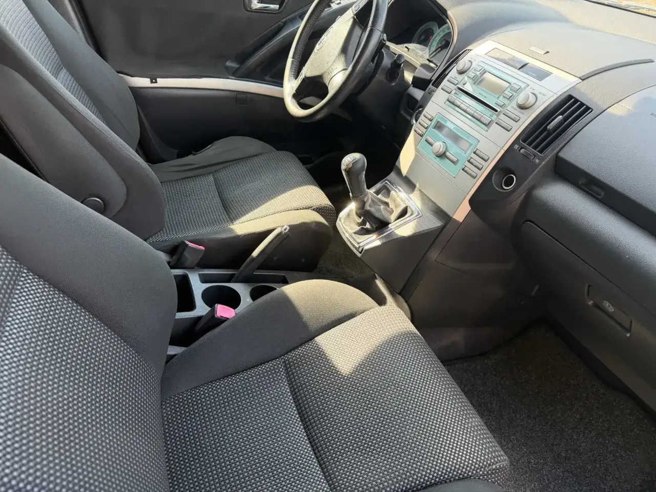 Wnętrze Toyoty Corolla Verso: siedzenia, kierownica, dźwignia zmiany biegów i konsola środkowa.