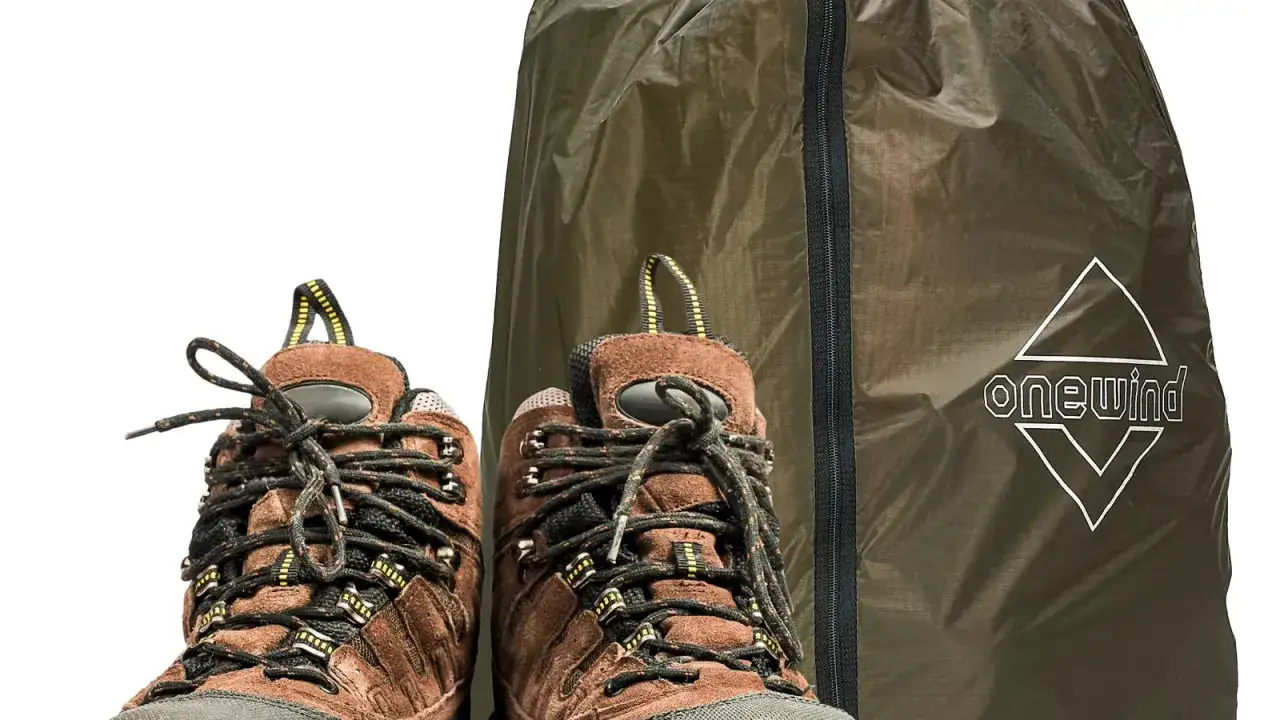 Brown hiking boots, showing signs of wear, sit beside a green storage bag. These shoes are falling apart in the closet, ready for a new adventure or retirement.