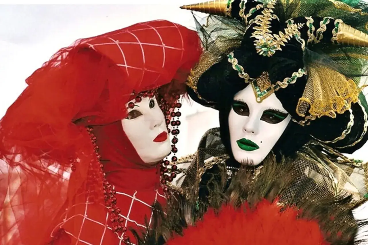 Twee gemaskerde figuren, één in rood met parels, de ander in groen en goud. Hun maskers verbergen hun ware gezicht, net zoals narcisten hun onzekerheid verbergen.