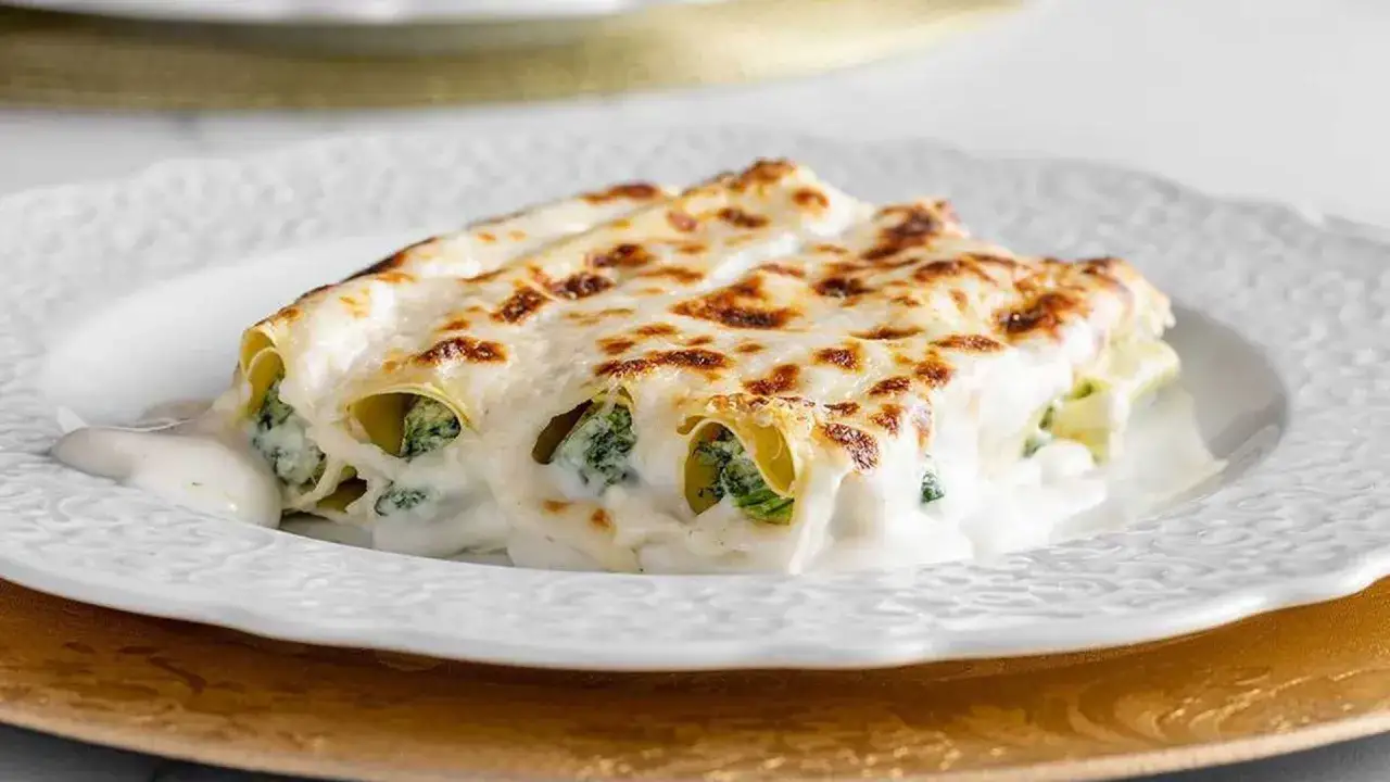 Cannelloni ricotta épinard gratinés, nappés d'une sauce crémeuse et dorés au four. Un délice !