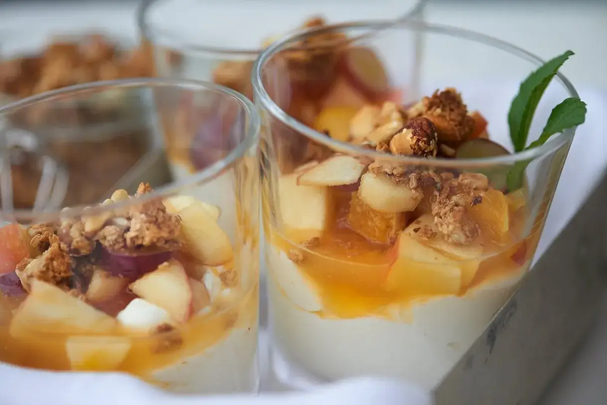 Leckere Gläser mit nachtisch mit griechischem joghurt, Früchten und knusprigem Granola.