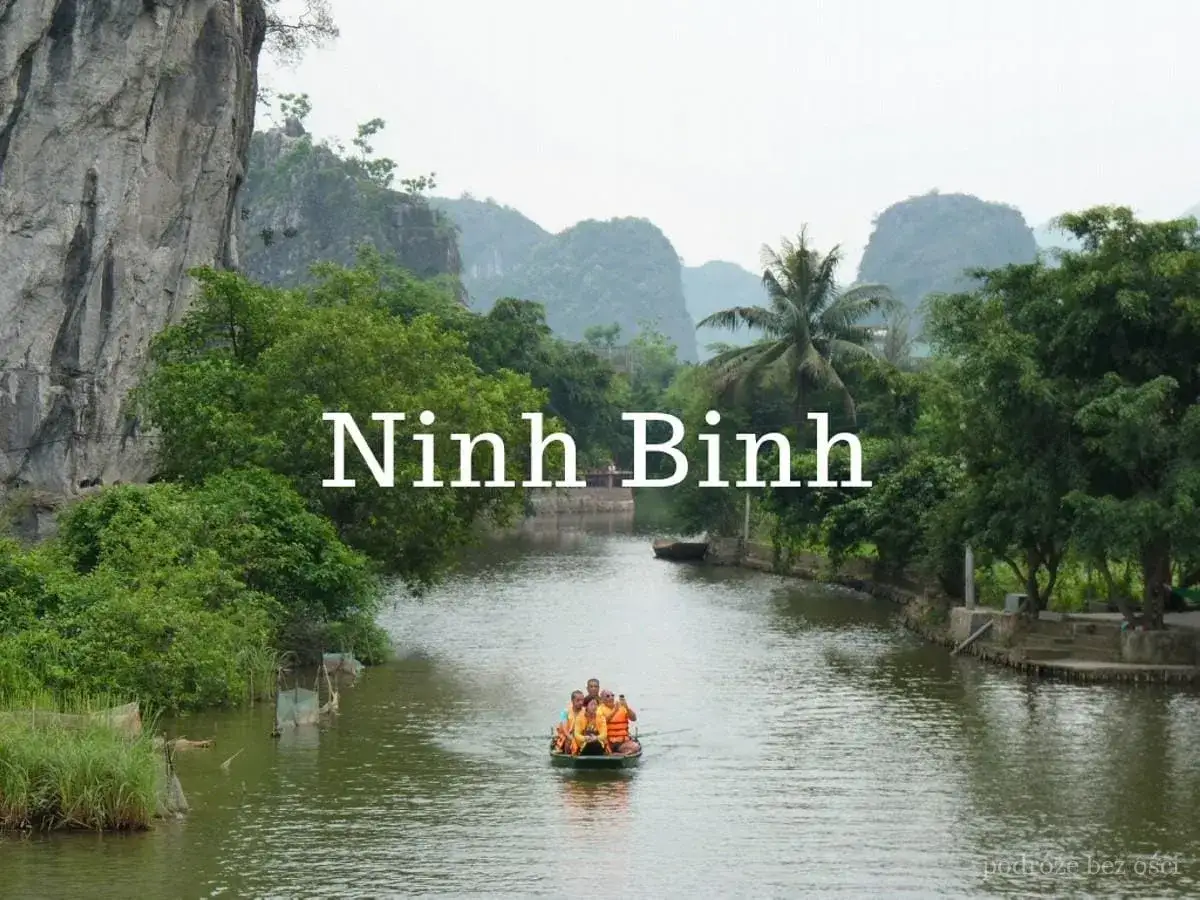 Rejs łodzią po rzece w Ninh Binh, otoczonej bujną zielenią i wapiennymi klifami.