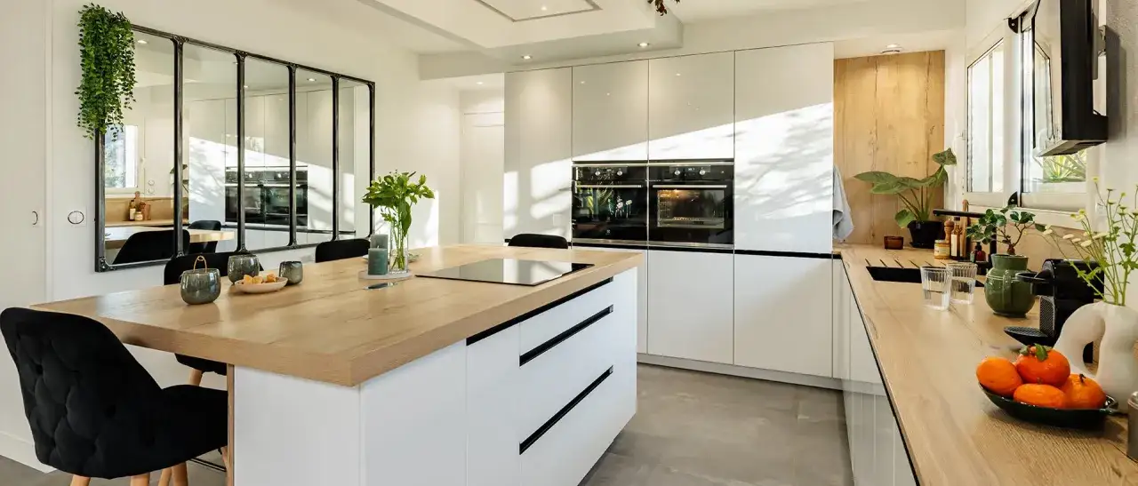 Cuisine moderne avec &icirc;lot central en bois, meubles blancs laqu&eacute;s et deux fours int&eacute;gr&eacute;s. Un mod&egrave;le de cuisine simple et &eacute;l&eacute;gant.