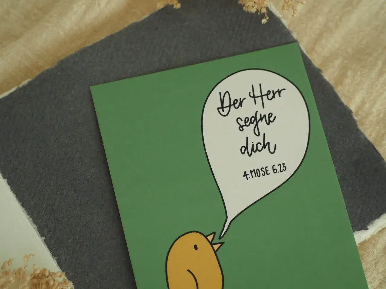 Ein süßer Küken-Aufdruck auf einer grünen Karte mit dem Bibelvers 