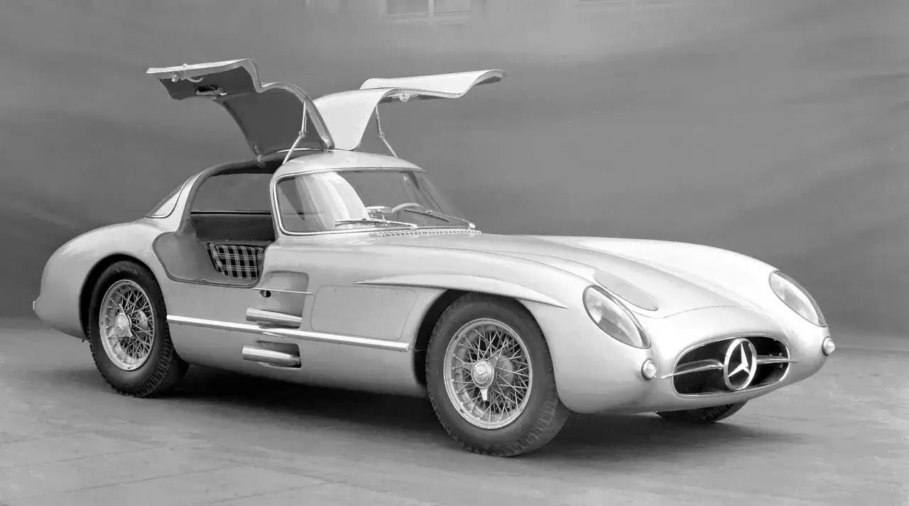 Srebrny Mercedes 300 z otwieranymi do góry drzwiami, klasyk motoryzacji, prezentuje swoje ikoniczne linie.