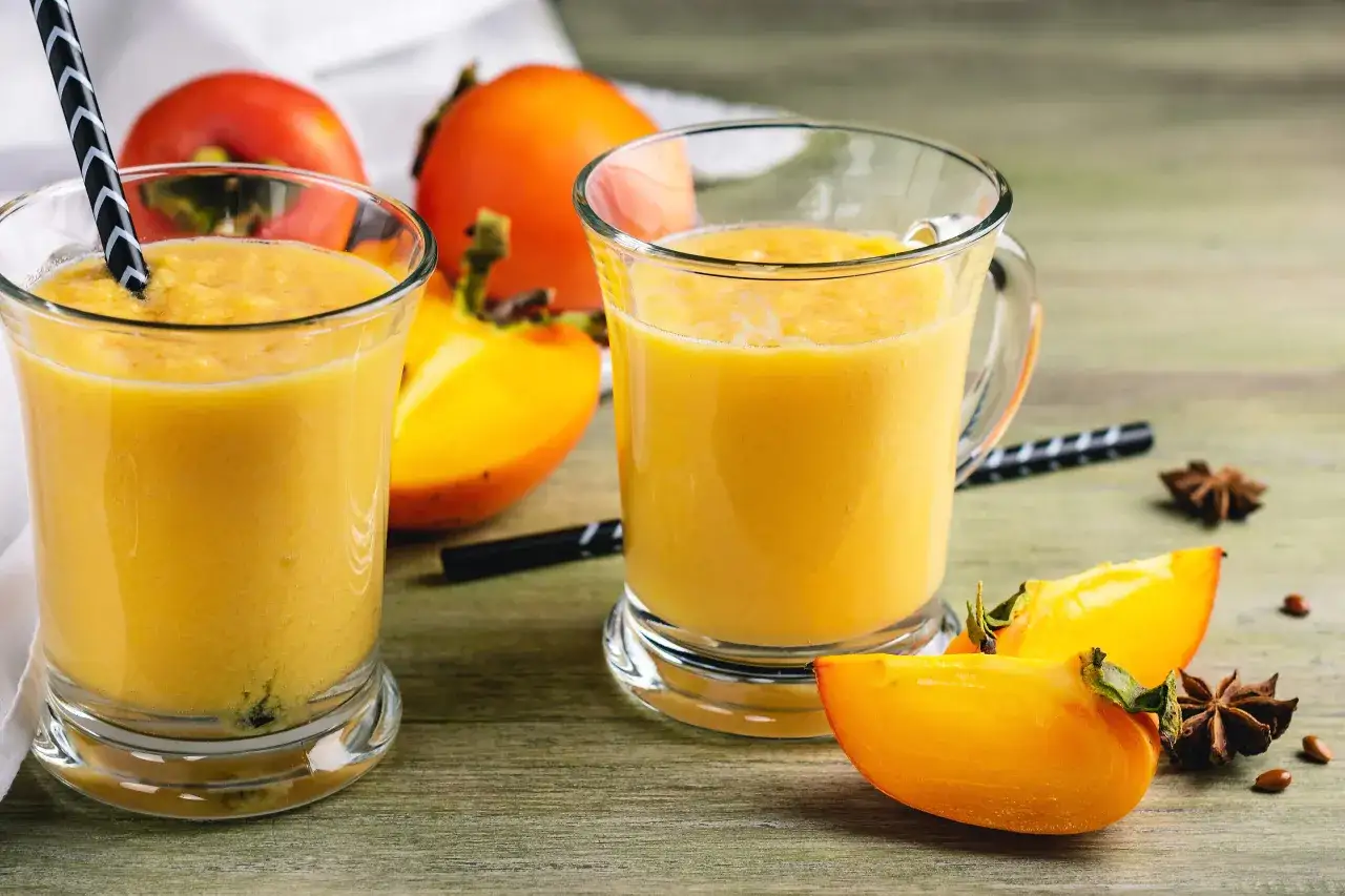 Dwa szklanki smoothie z owoców kaki, które dzięki swoim właściwościom są idealne na zdrowy napój.