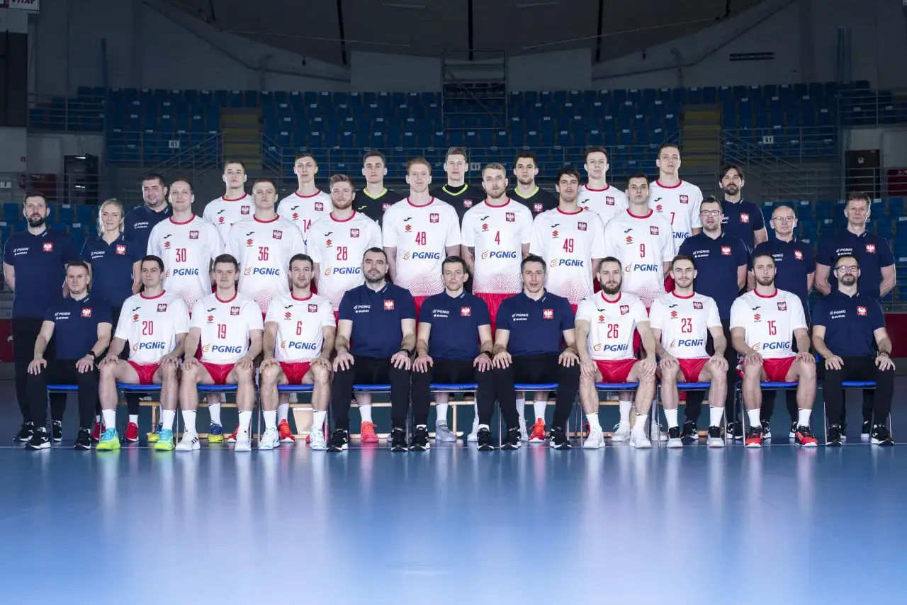 Drużyna piłkarzy ręcznych Polski w białych strojach z orzełkiem. Oto najlepsi piłkarze ręczni Polski, gotowi do gry.