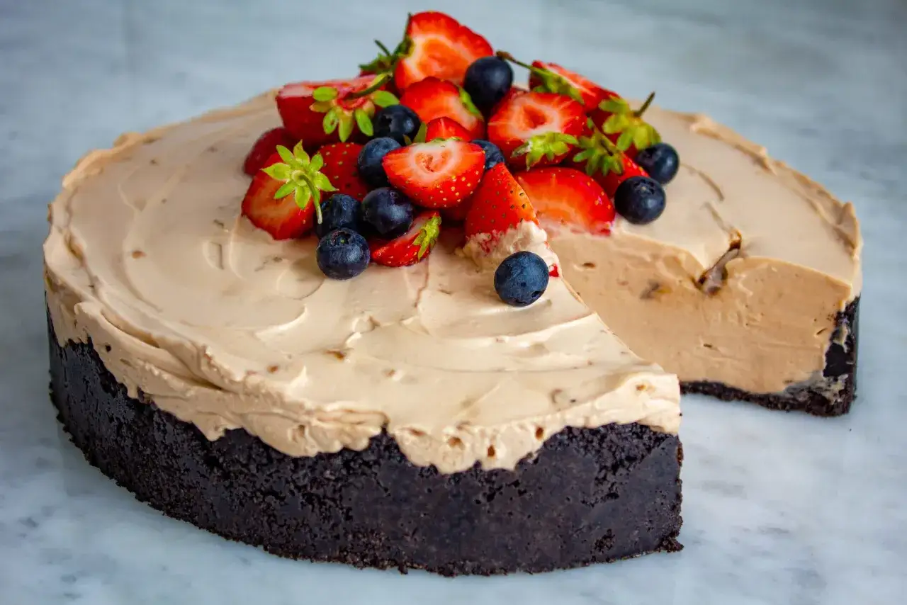 En kr&auml;mig daim cheesecake med chokladbotten, toppad med f&auml;rska jordgubbar och bl&aring;b&auml;r. En dr&ouml;m f&ouml;r alla som &auml;lskar s&ouml;tt!