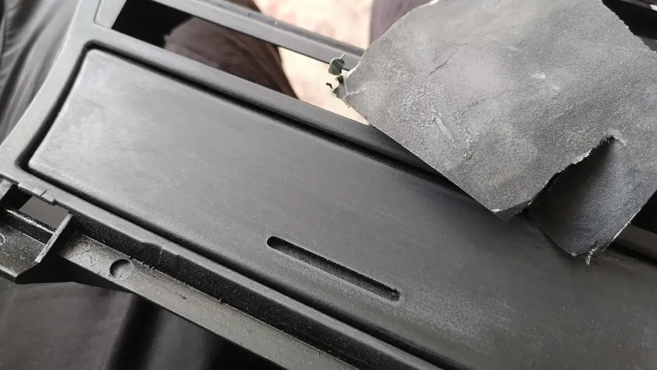 Szlifowanie elementu przed malowaniem plastiku sprayem.