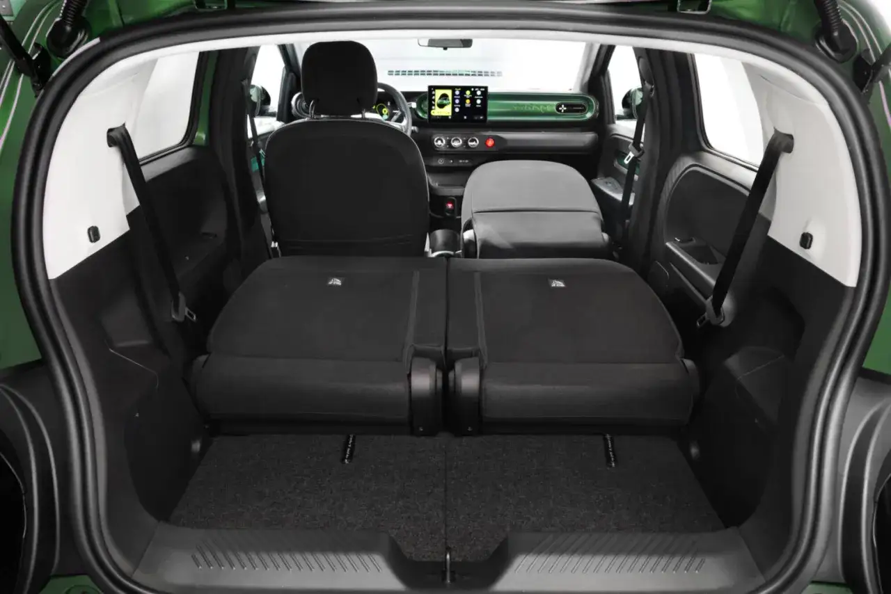 Widok bagażnika zielonego Renault Twingo Electric. Tylne siedzenia złożone, tworząc płaską przestrzeń.