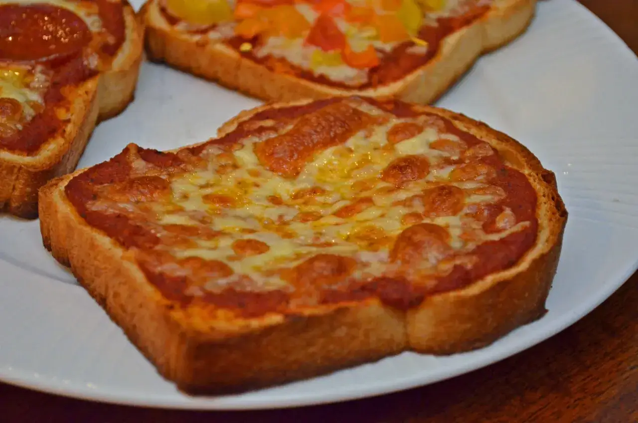 Pyszna pizza z chleba tostowego z roztopionym serem i sosem pomidorowym. Idealna na szybką przekąskę.
