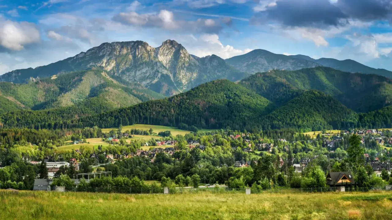 Malowniczy widok na jaszczurówkę w Zakopanem, z górami w tle i zielonymi wzgórzami.