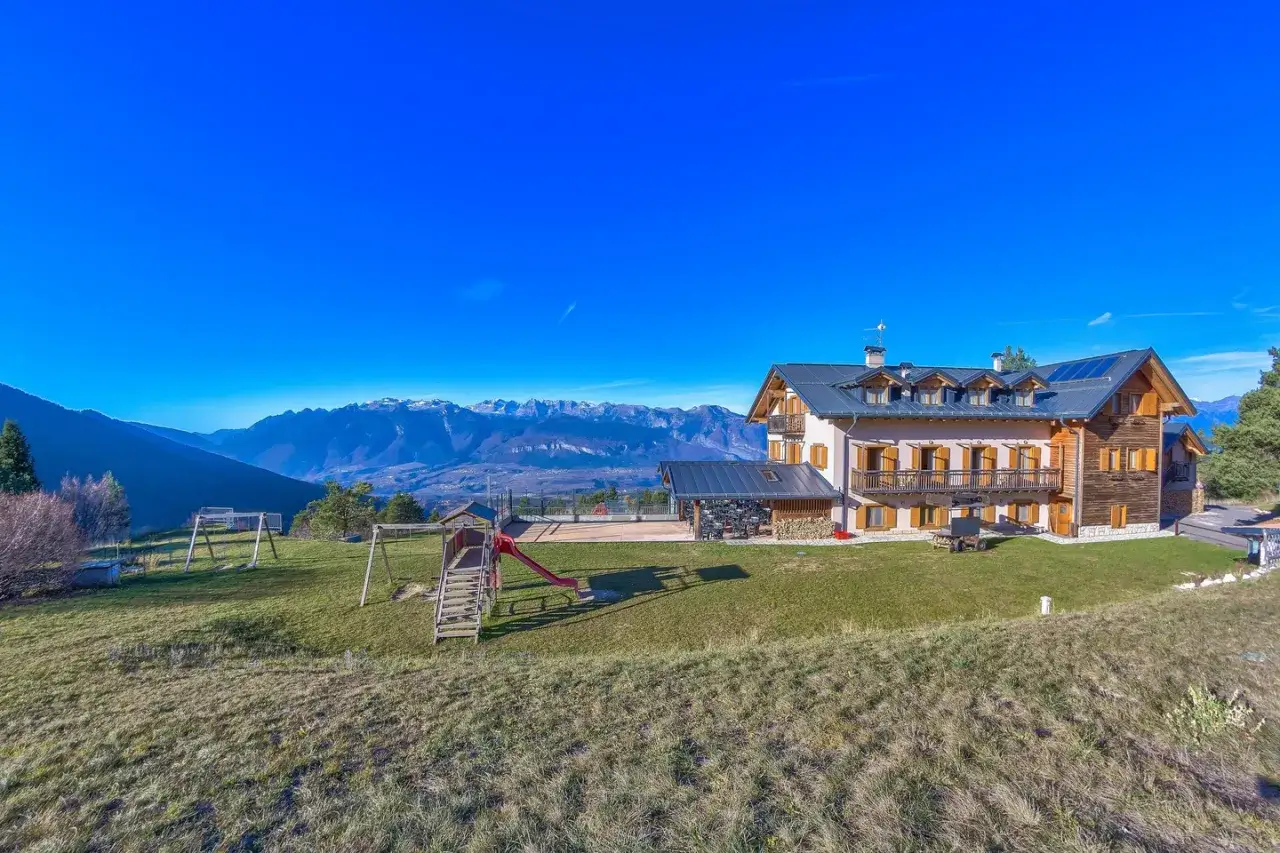 Il rifugio Predaia, con giochi per bambini e vista sulle montagne innevate, offre un soggiorno immerso nella natura.
