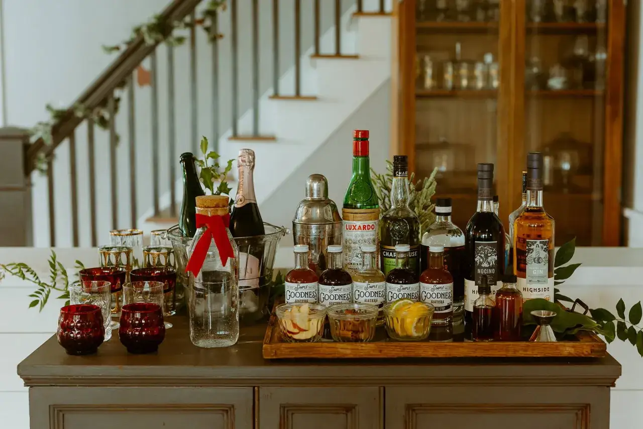 Elegancki barek z butelkami alkoholi, kieliszkami i dodatkami do drinków, idealny na **cosmopolitan** przyjęcie.