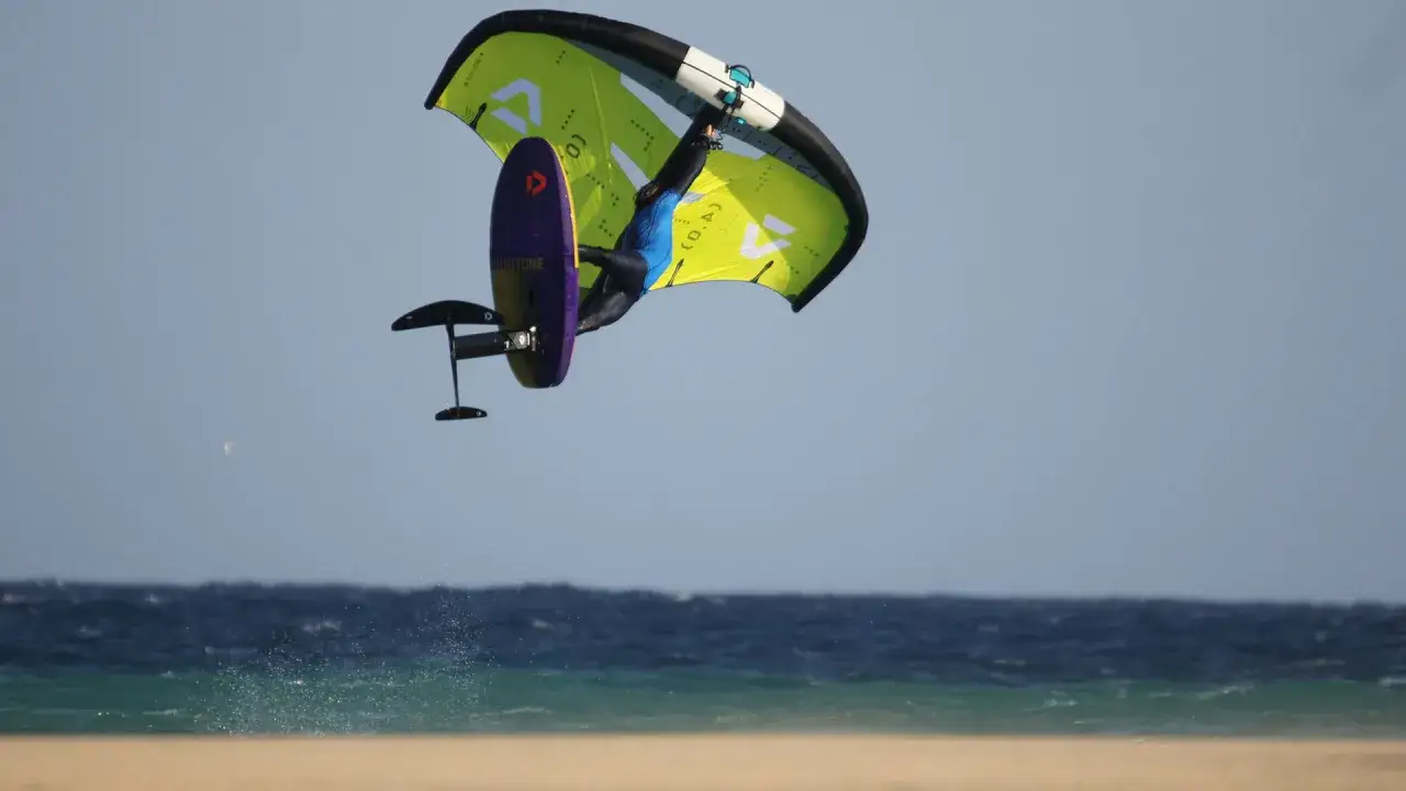 Wingfoiler springt hoch über dem Meer bei Costa Calma. Ein Action-Shot vom Ion Club.