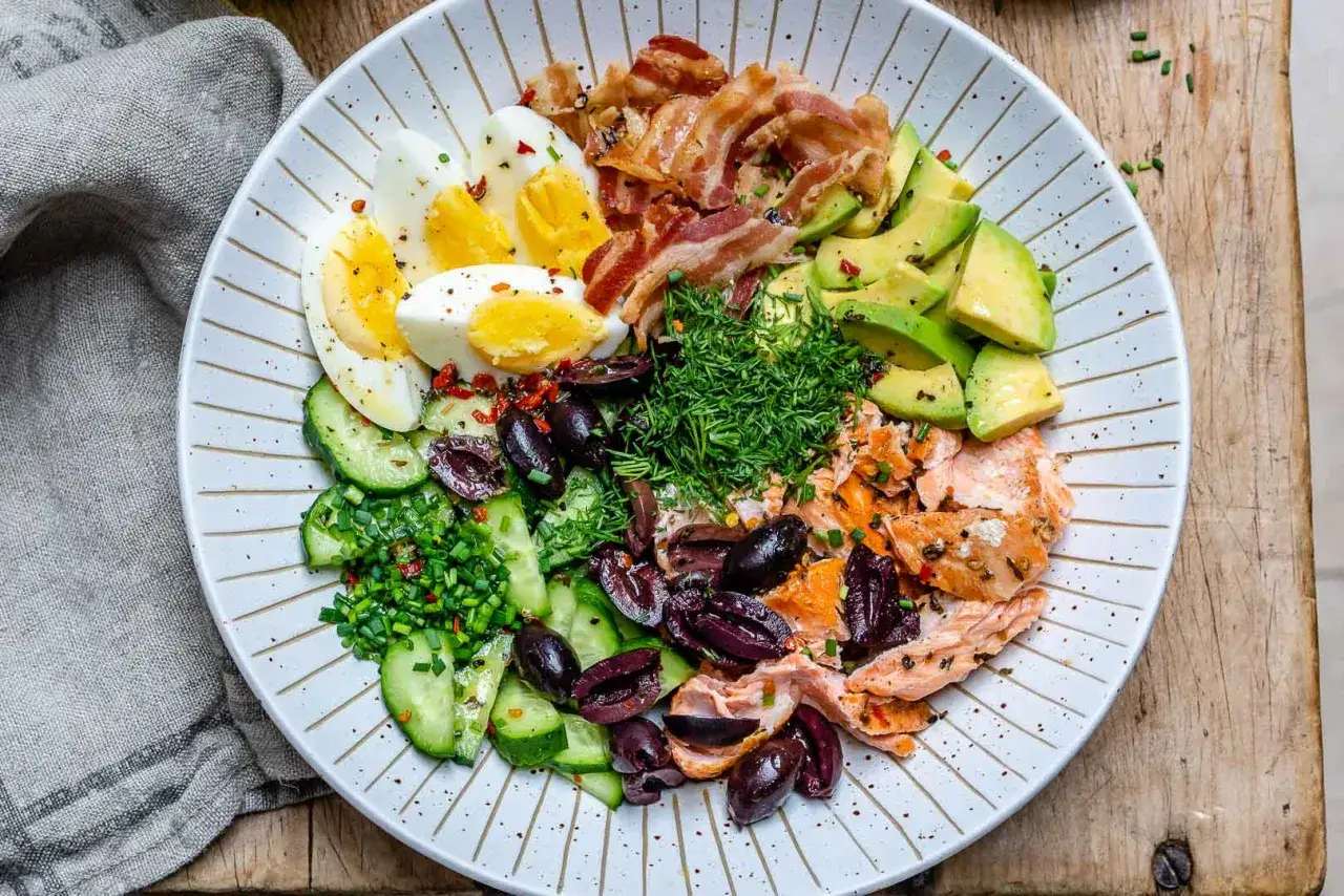 Kolorowa sałatka z łososiem, jajkami, awokado, boczkiem i oliwkami – idealna na keto dietę.