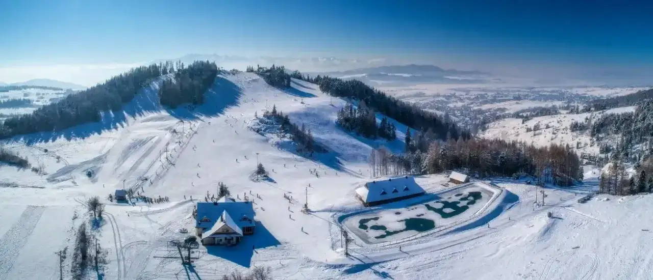 Ośnieżone stoki narciarskie w Czorsztynie, z widokiem na góry. Sprawdź czorsztyn ski cennik i zaplanuj zimowy wypad!