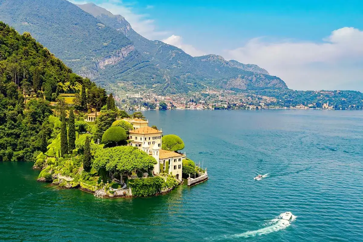 Malownicza wyspa Isola del Garda z willą i bujną zielenią, otoczona turkusową wodą jeziora.