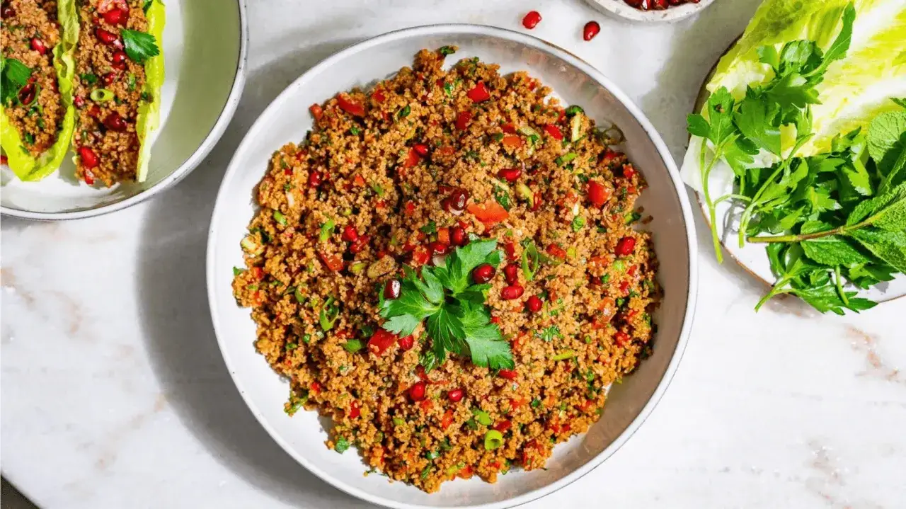 Ein köstliches Kisir Rezept mit Granatapfelkernen und frischen Kräutern, serviert in knackigen Salatblättern.