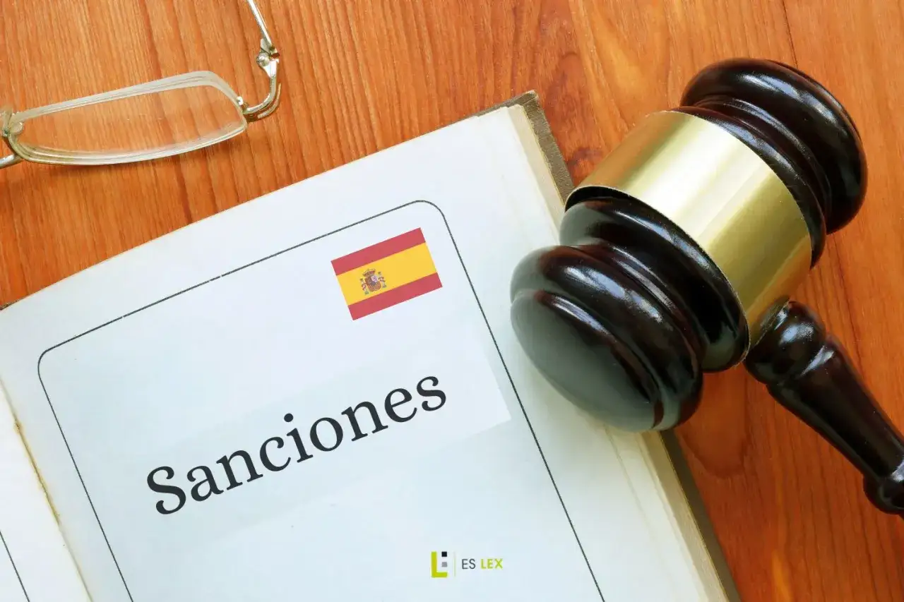 Martillo de juez sobre libro abierto con bandera espa&ntilde;ola y texto 