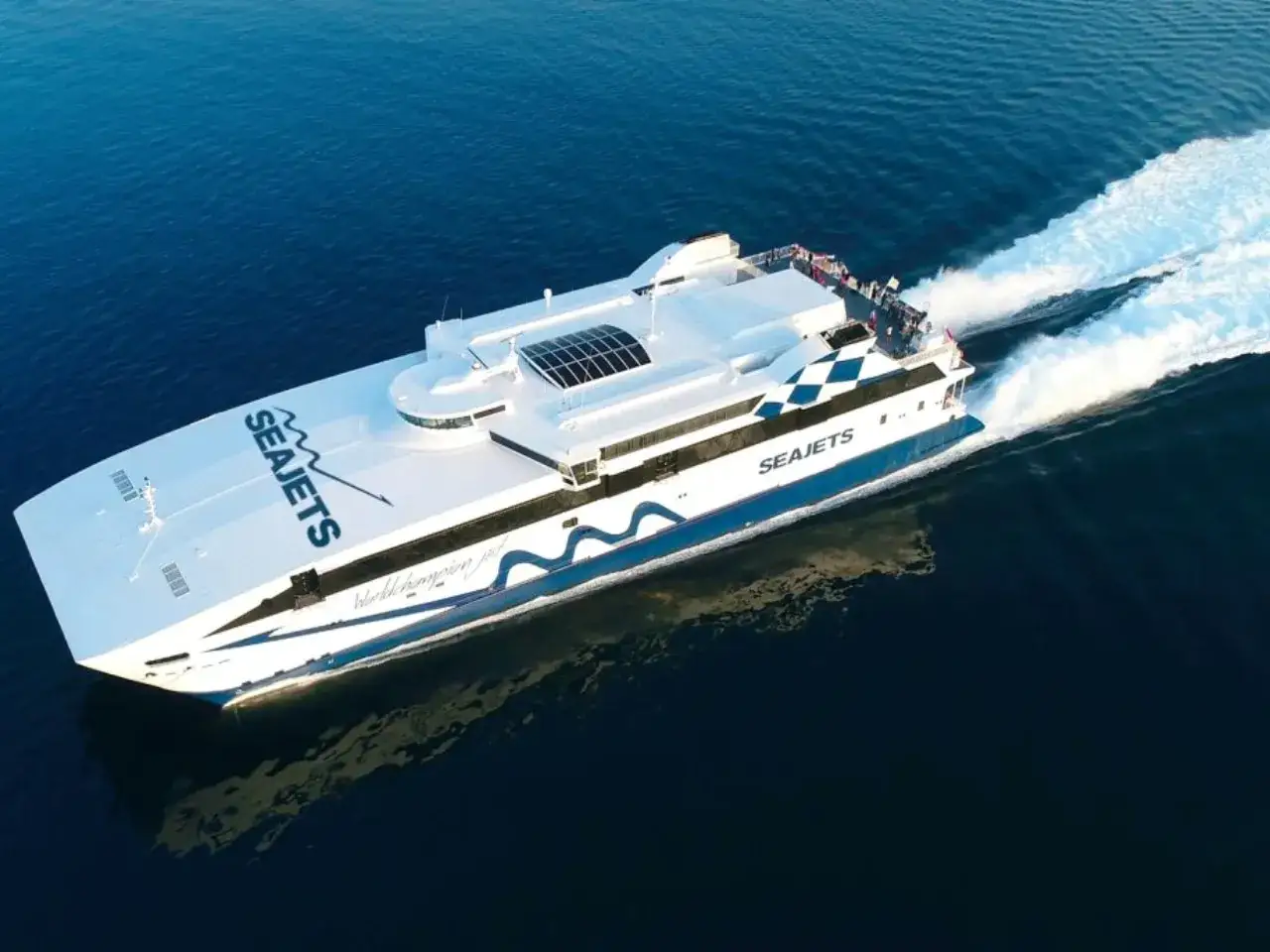 Szybki prom SeaJets pędzi po morzu, gotowy na wycieczkę na Santorini z Krety.