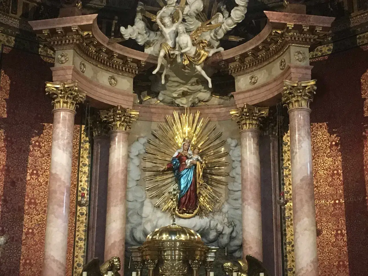 Ołtarz z figurą Matki Boskiej z Dzieciątkiem, aniołami i bogatymi zdobieniami. Wzniosła scena przypomina o radości z psalm 47.