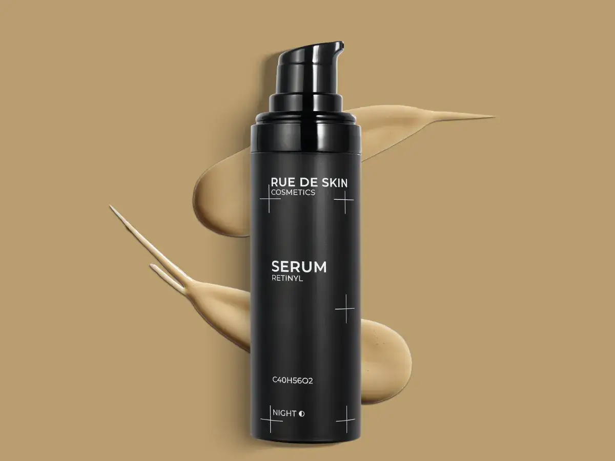 Czarny flakon serum z retinolem od Rue de Skin, otoczony smugami kosmetyku.