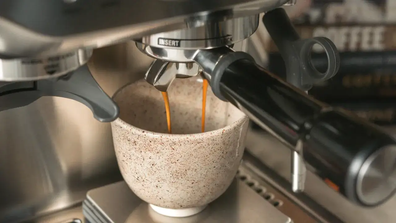 Frisch gebrühter doppelter Espresso fließt in eine rustikale Tasse.