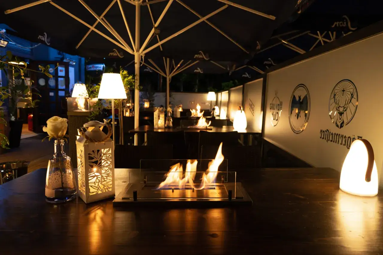 Gem&uuml;tliche Atmosph&auml;re mit Feuerschale und Beleuchtung auf einer Terrasse. Perfekt f&uuml;r eine entspannte party in Bergisch Gladbach.