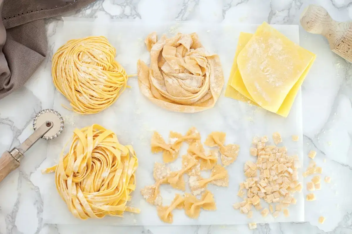 Vari tipi di pasta fresca: tagliatelle, farfalle, sfoglie per lasagne e maltagliati. Il maccarone significato &egrave; un mondo di sapori.